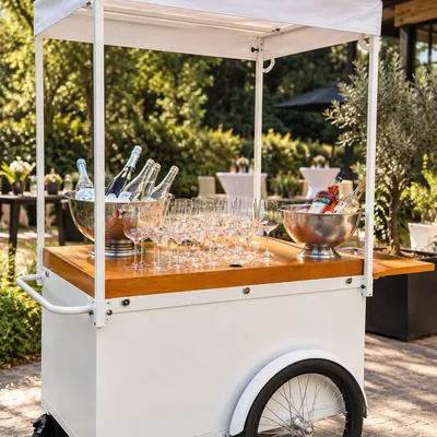 Market Cart als Getränkebar mit Sektflaschen im Eiskübel und bereitstehenden Gläsern